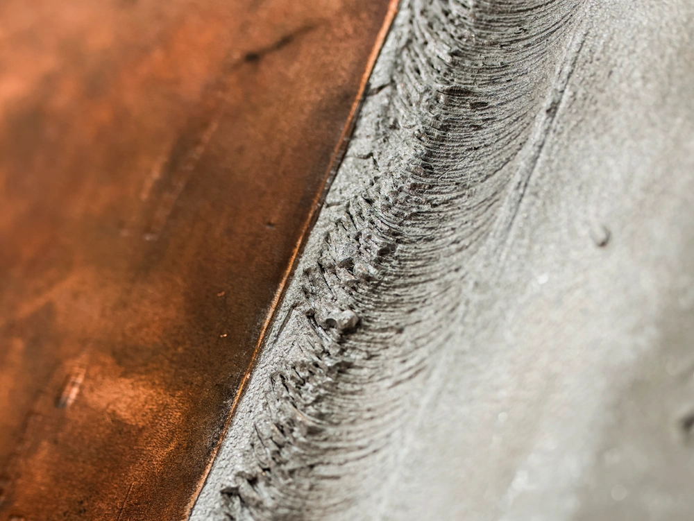 Zdjęcie przedstawia eksponat „próbka FSW – aluminium-miedź” na stoisku Łukasiewicz – GIT podczas targów WeldTech 2026